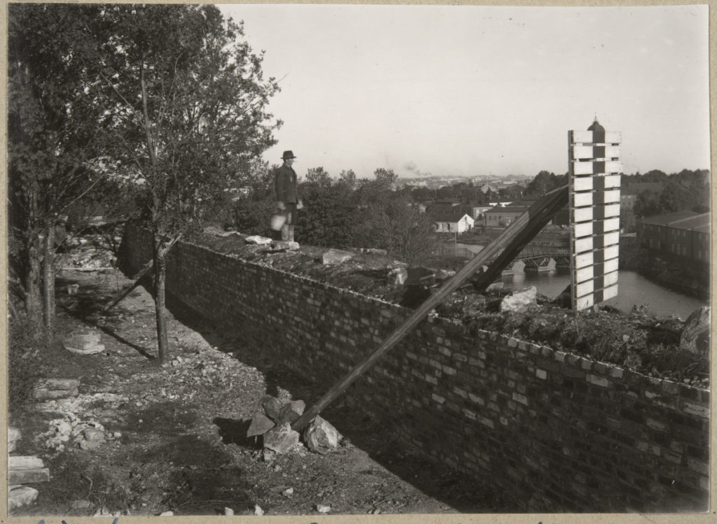 Svartvit bild av en man på en nyrestaurerad mur på Sveaborg. 