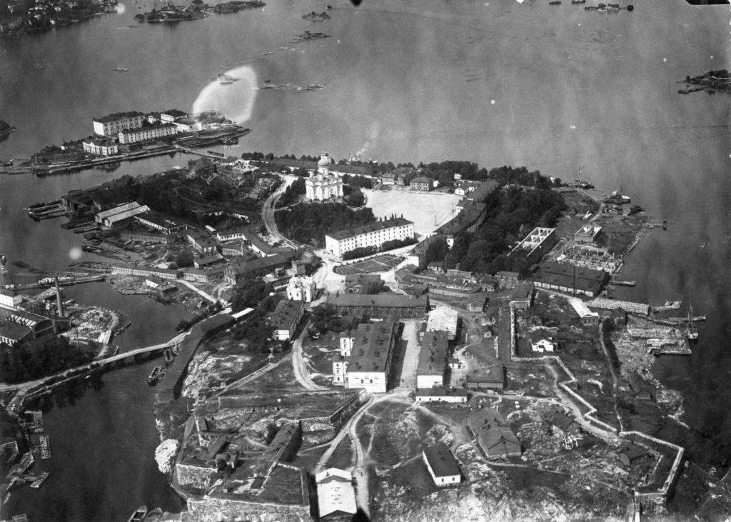Svartvitt flygfoto över Stora Östersvartö på 1920-talet. Kyrkan som inte ännu renoverats syns tydligt.