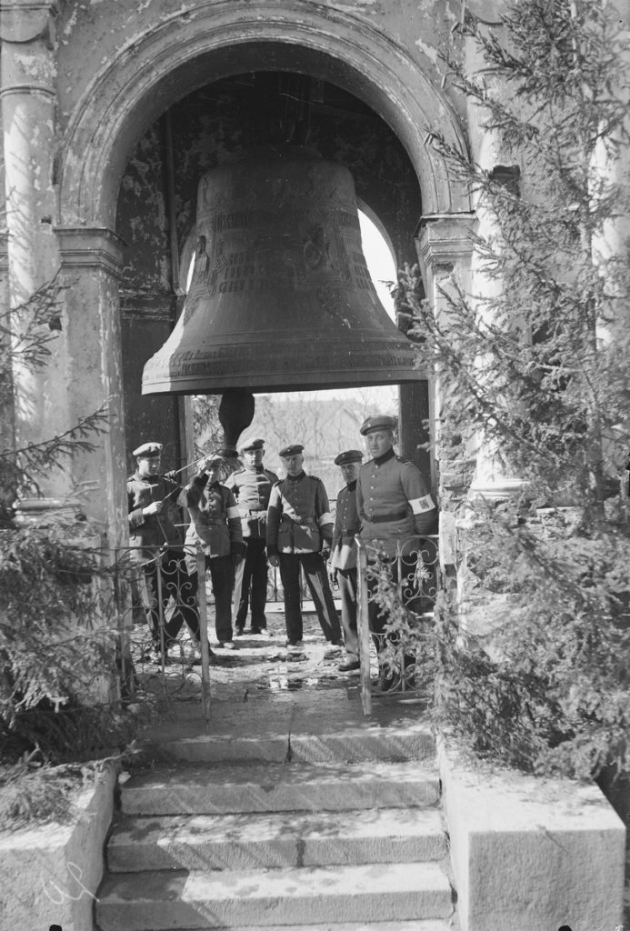 Sveaborgs kyrkklocka med Sveaborgs kyrkklocka. Under klockan står Kustartilleriregemente 1 män som står under den