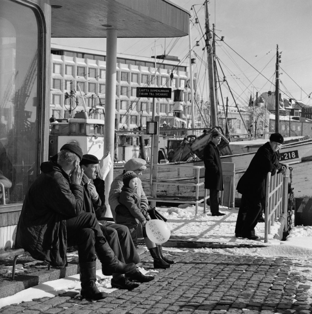 Människor sitter utomhus i vårsolen. urban hamnmiljö.